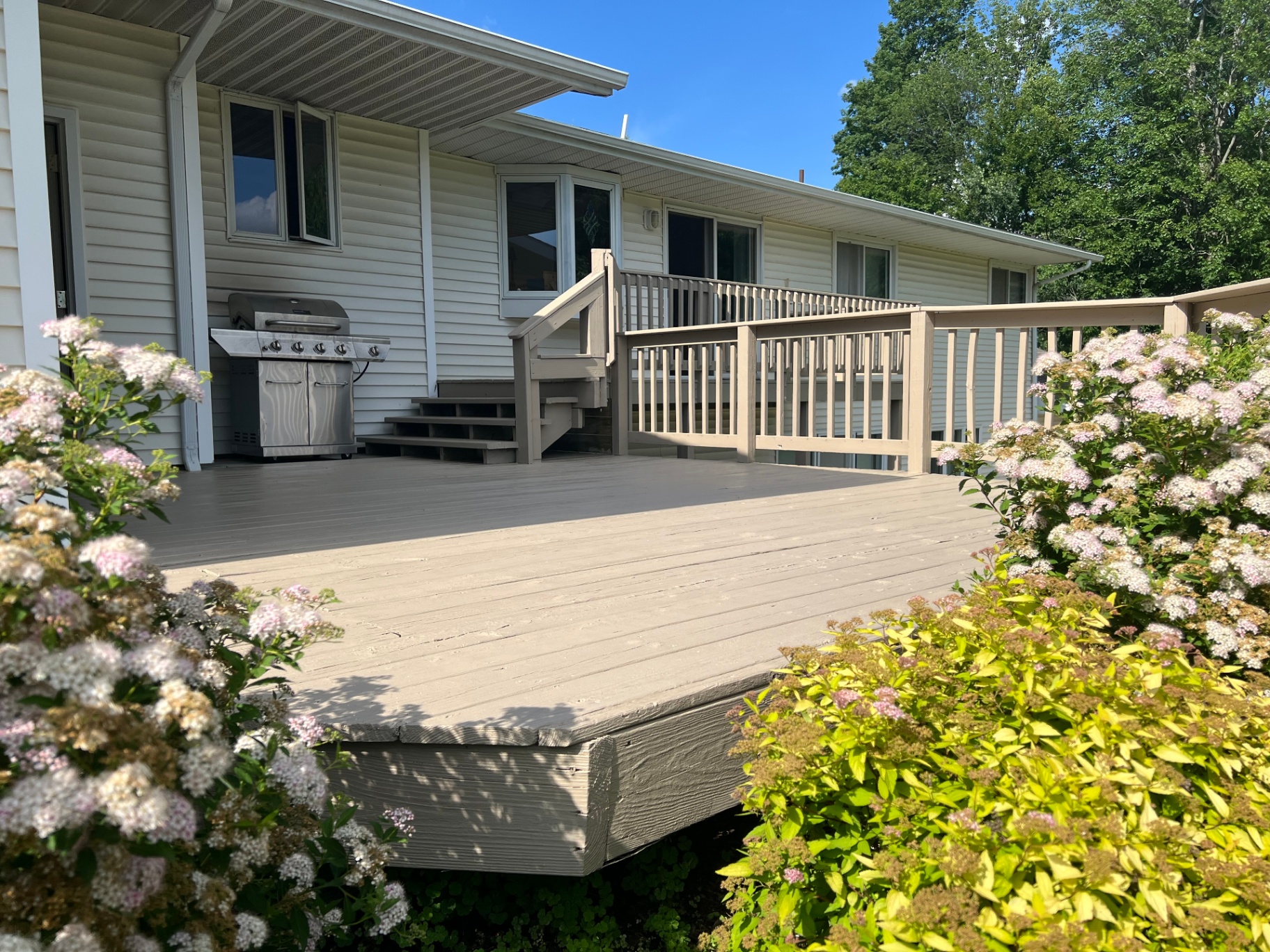 Freshly refinished deck with two-tone railing and steps
