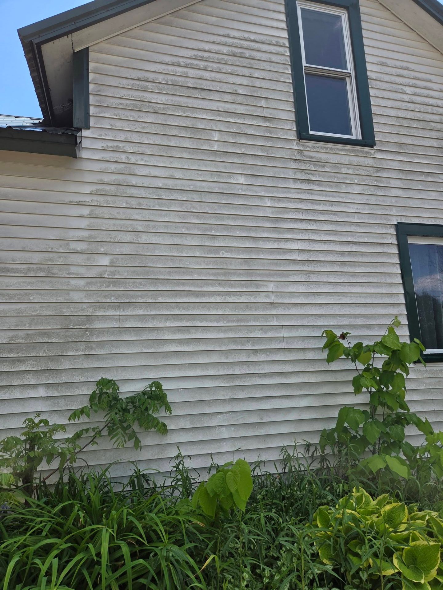 Weathered vinyl siding before power washing
